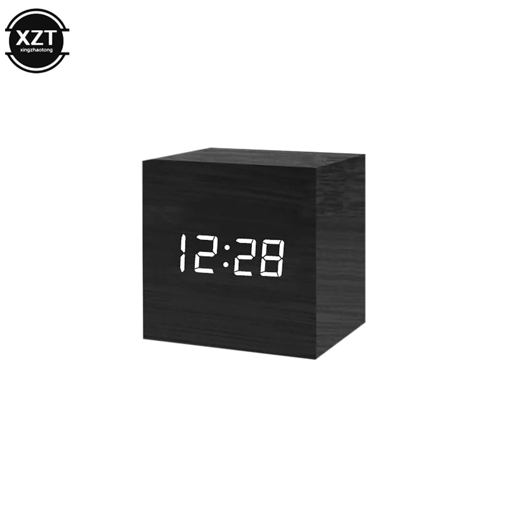 Black digital clock with wooden texture displaying the time 12:28 on a white background.
